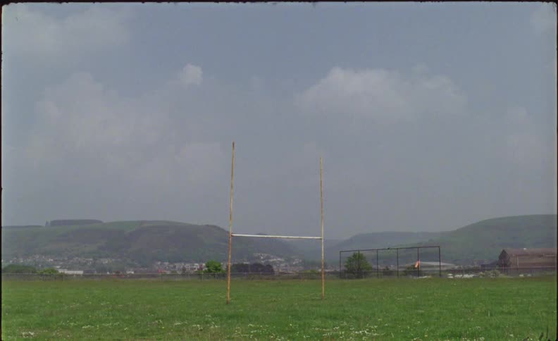 The football goal sits on the green field
