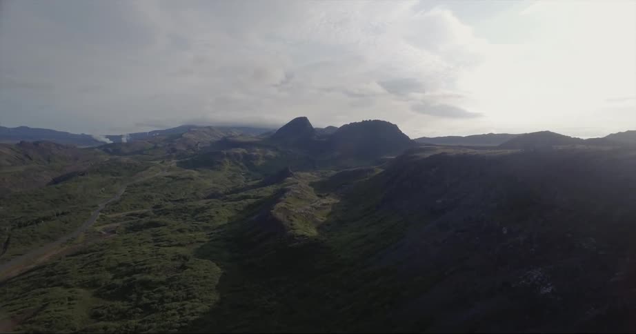 The green hills are covered with slight fog