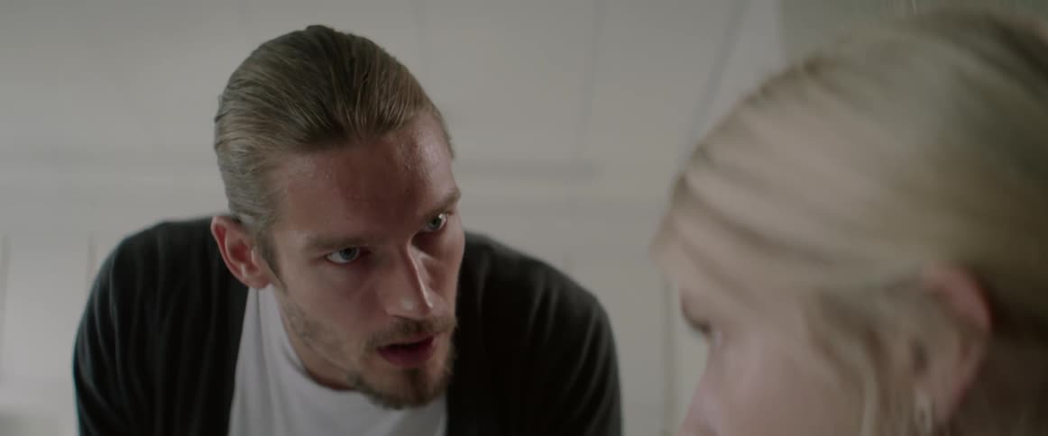 A serious young man talks angrily to a blonde woman during a disagreement.