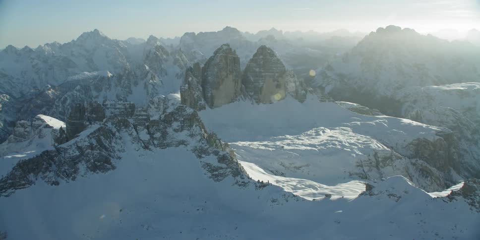 The sun shines over snowy mountains