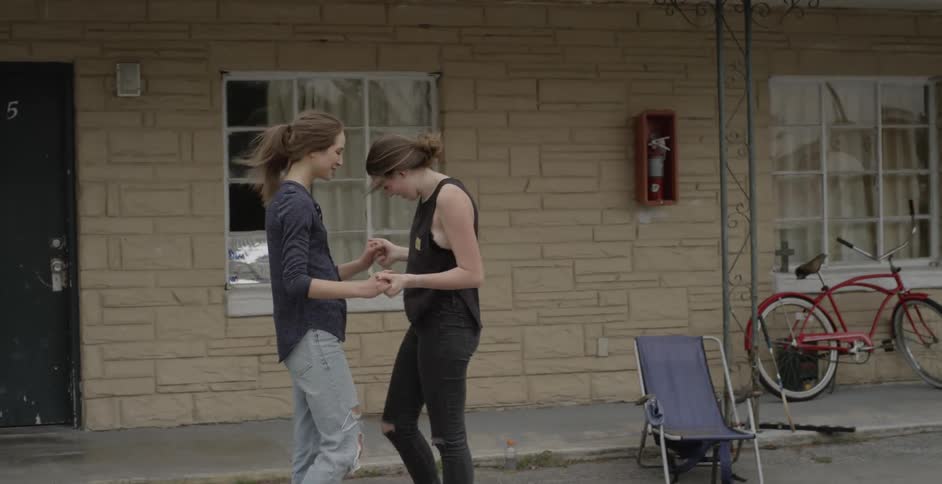 Two women smile and greet each other