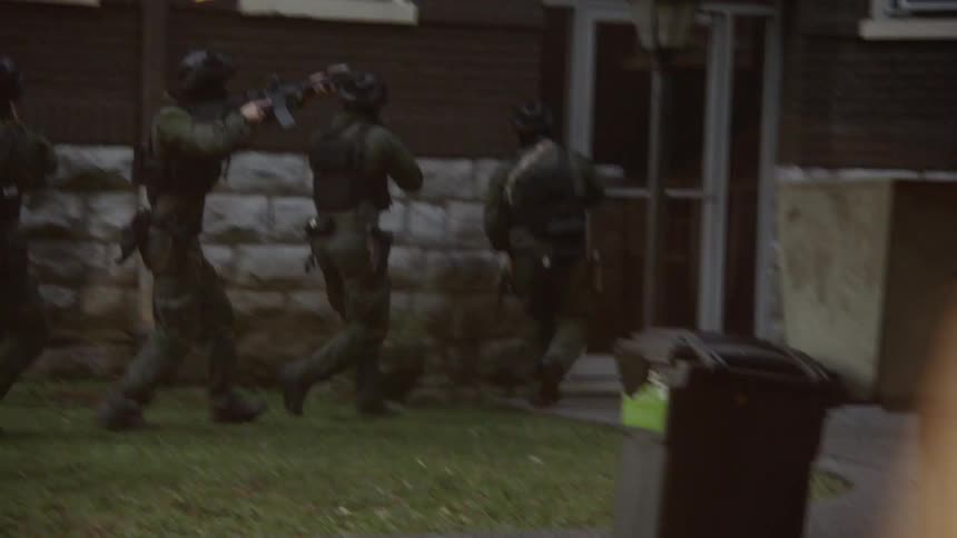 A swat team approaches a building