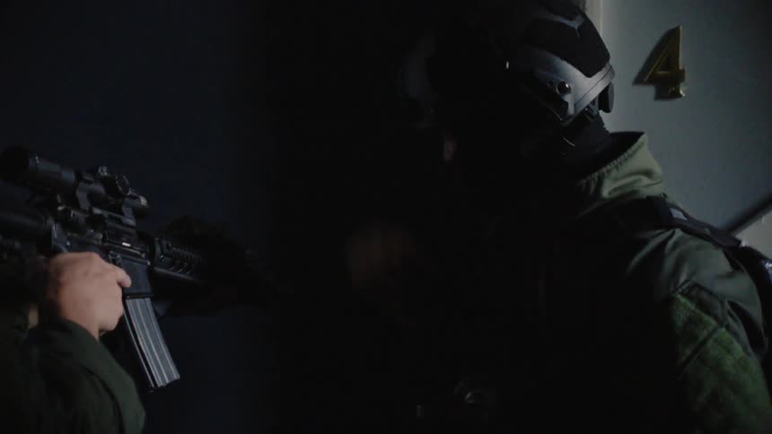 A swat team storms a building
