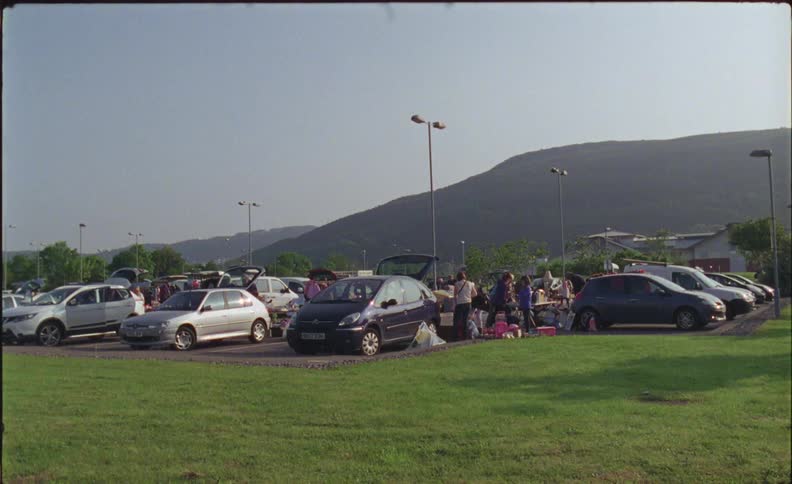 People shop in a parking lot yard sale