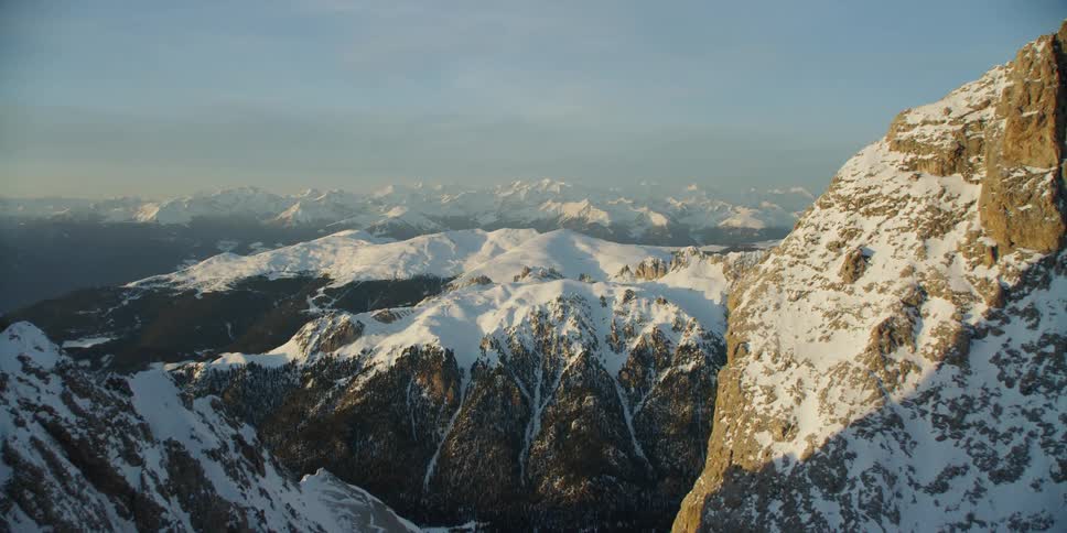 Snow covered mountains sit under a blue sky