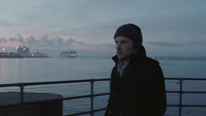 A man walks along the pier at sunset