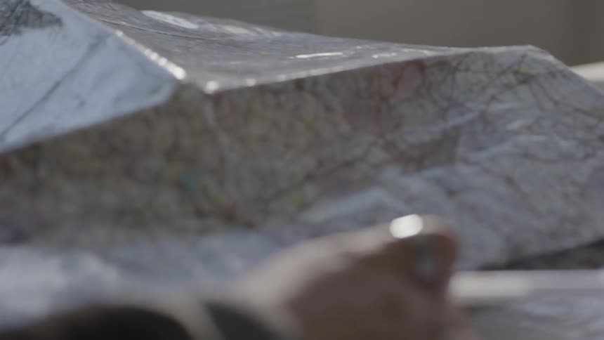 Person sitting at table is looking at road map