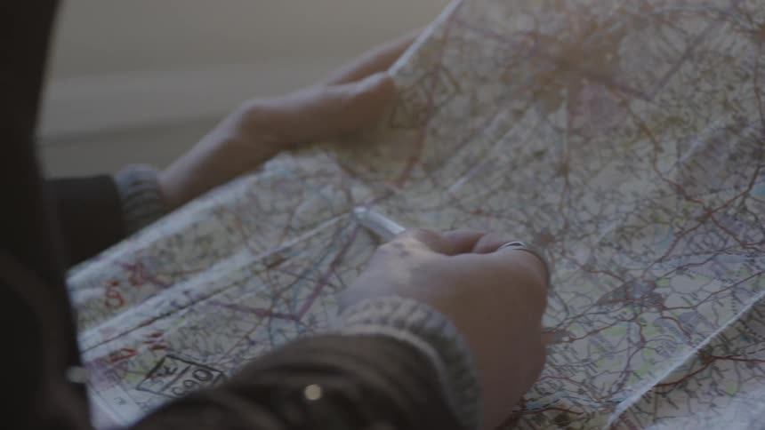 Person sitting at table is looking at a map