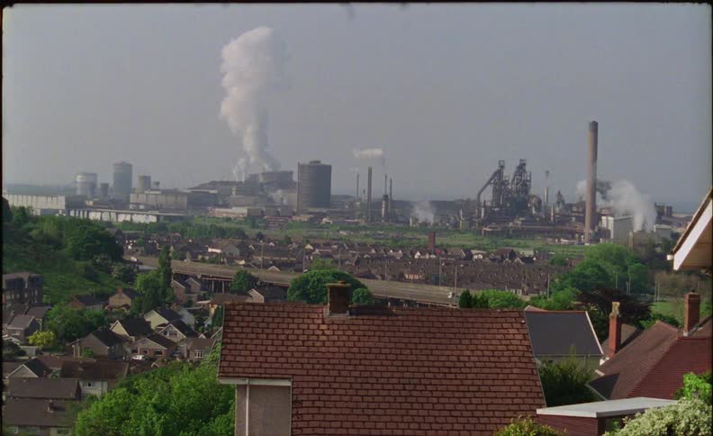 A highway runs past a neighborhood and factory