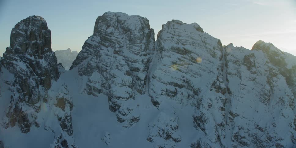The sun sets over snowy mountain peaks