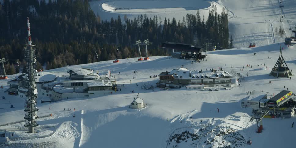The ski lift is transporting people around the tall mountain ski resort