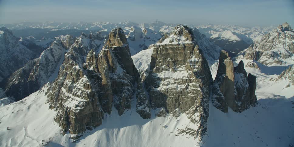 The tall pointy mountains are covered with heavy snow