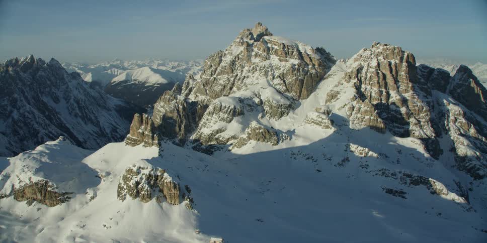 The wide mountain range has heavy snow up the side