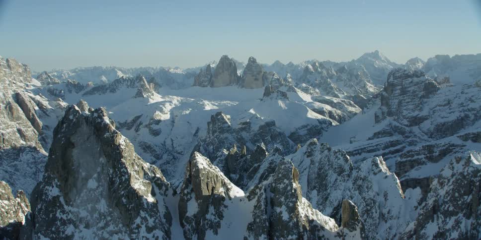 The long snow covered mountains are covered with bright sunlight at the top