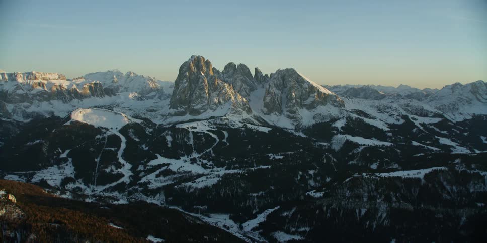 Rocky peaks and slopes with snow trails on a sunny day