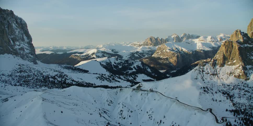 A small trail runs up and around the mountains covered with snow