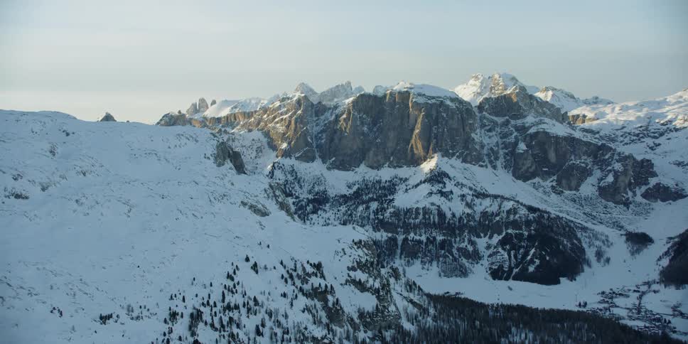 Snow covered mountains sit under a sunny blue sky