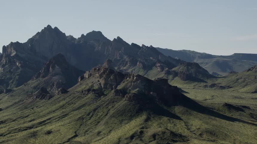 The mountains are covered with dark stone and green