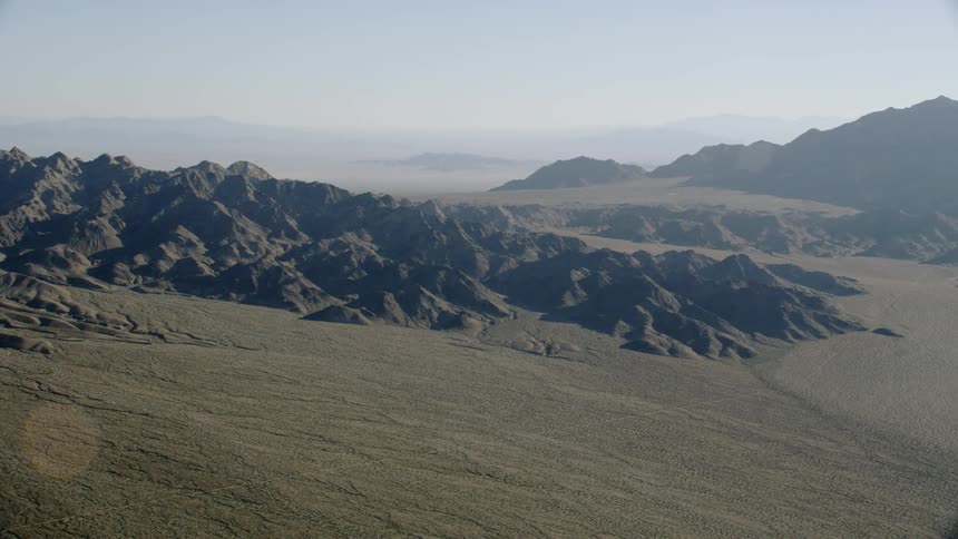 Sweeping aerial views of desert mountains and landscapes