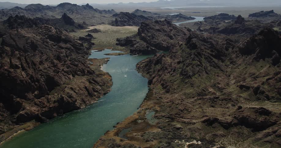 The river cuts through dark mountains and steep canyons