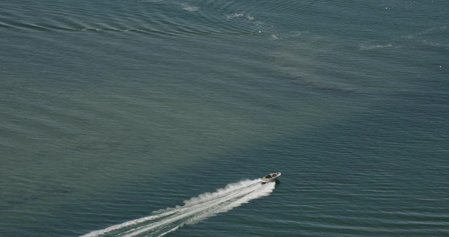 Slow motion aerial view of a racing motor boat
