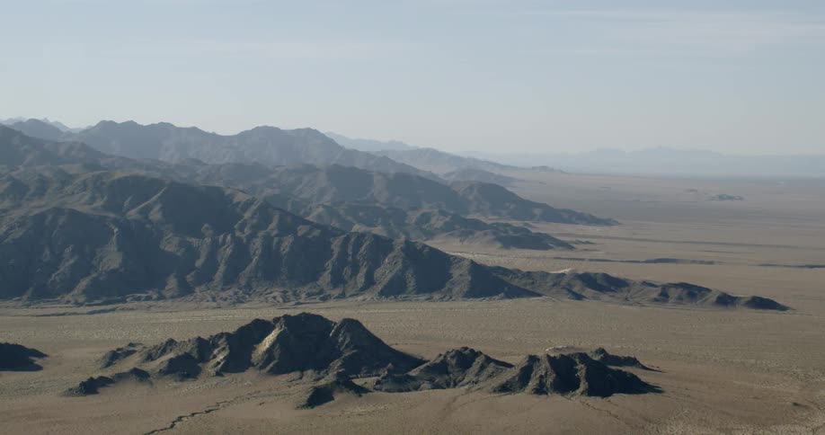 Mountains sit in the desert sand dunes