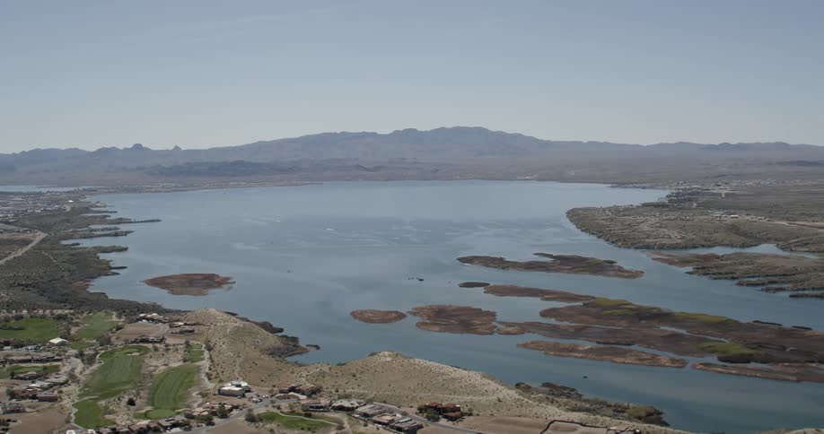 A calm lake sits under a blue sky