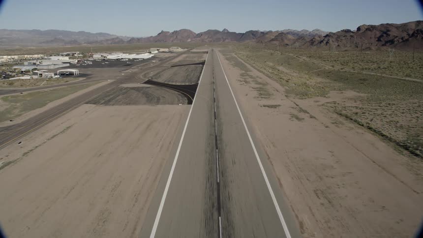 The runway is long leading towards a mountain range