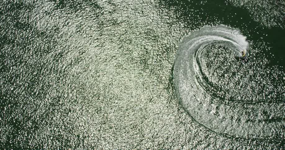 Jet ski traveling in a circle on body of water on sunny day