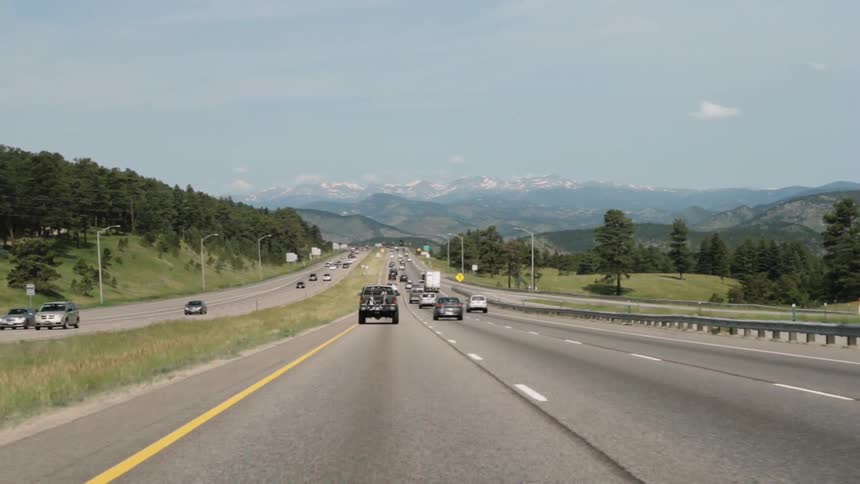 Cars travel on an interstate near mountains
