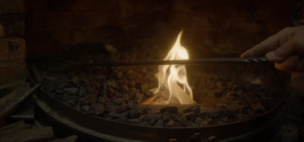 Coals are raked over a fire