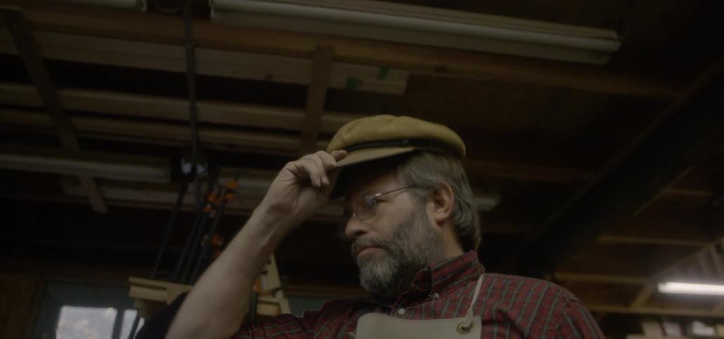 Man wearing glasses puts a cap on his head