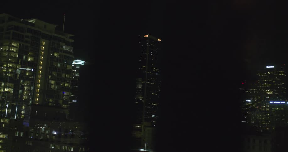 City buildings illuminate the dark night sky