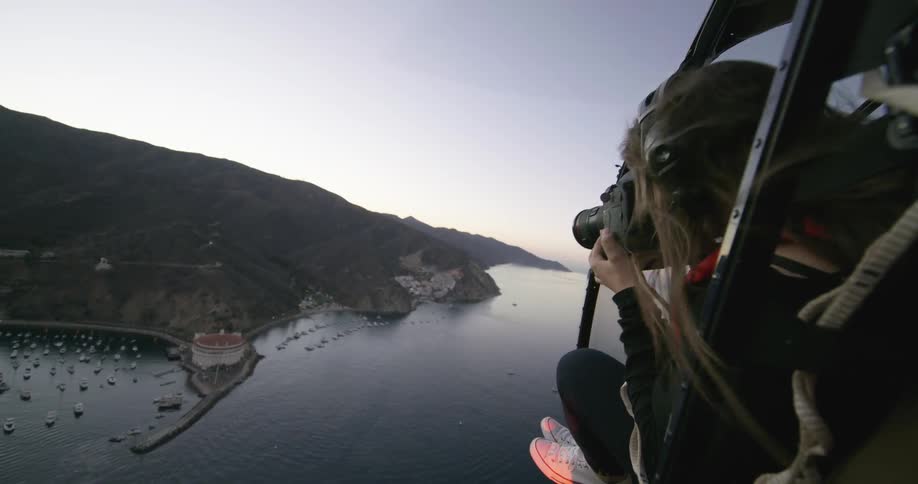 A woman takes a photograph from a flying helicopter