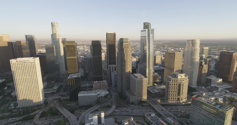 Sun shining on a city skyline as traffic flows along the highway