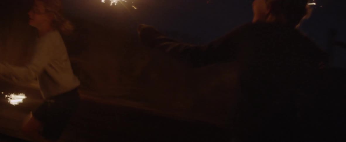 Children are waving sparklers around in the dark