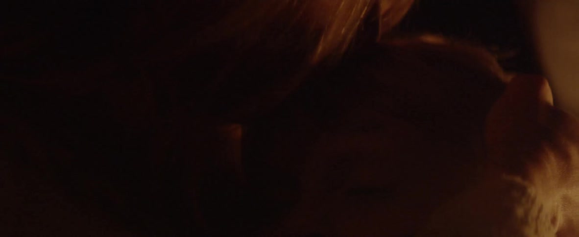 A woman holds and kisses a child in the dark