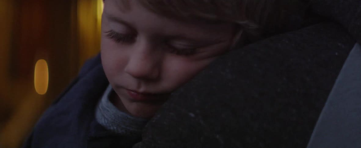 An adult holds a sleeping boy