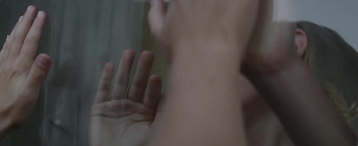 Two children play from inside and outside of a house