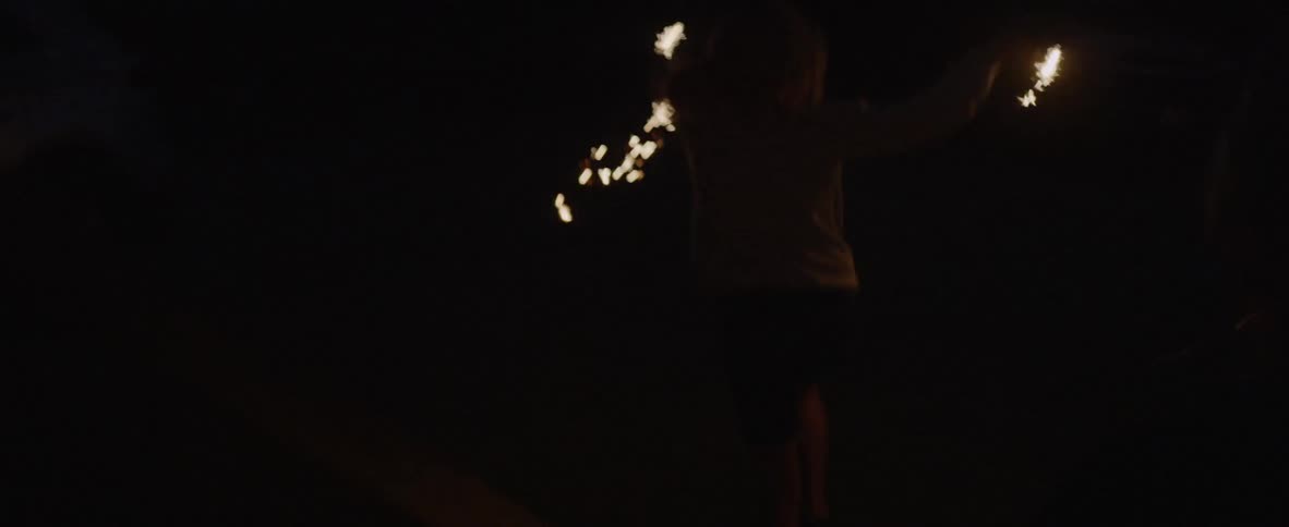 Children run down outdoor stairs with sparklers