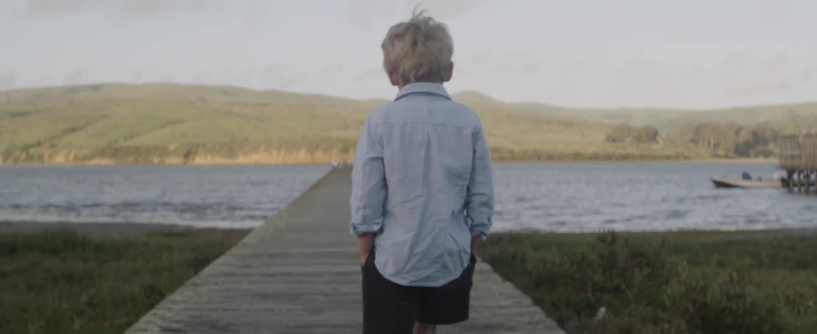 A child slowly walks out onto the pier
