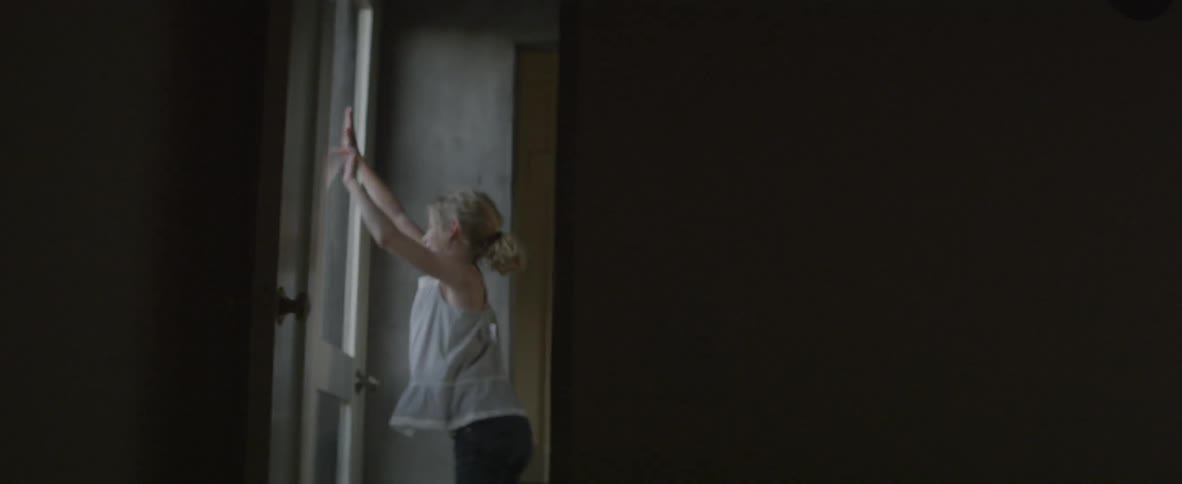 A girl pats the window and plays in the hall