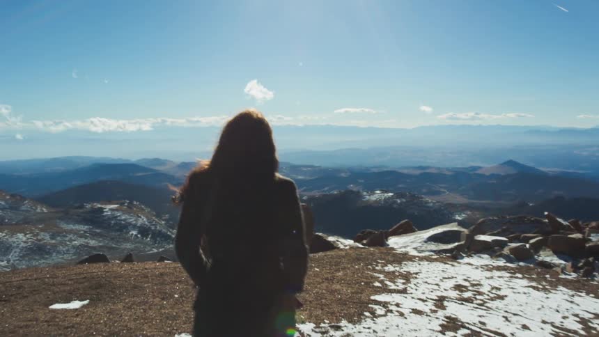 A woman is walking toward a cliff