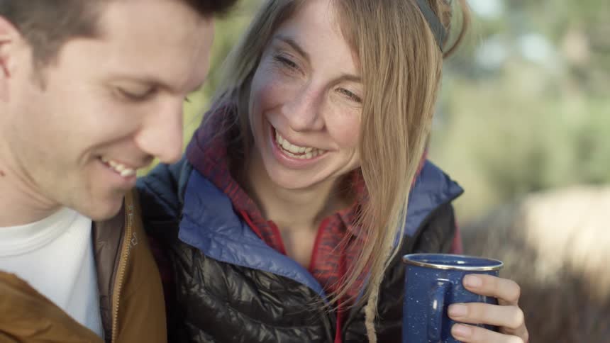 Man and woman laugh as they look at something