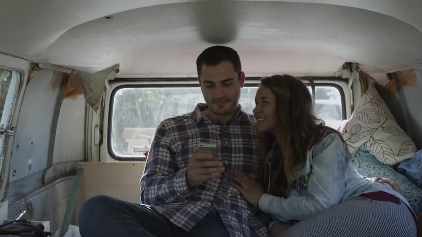 A man and woman sitting in the back of a moving van