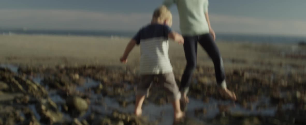 Two children play in muddy sand by the beach