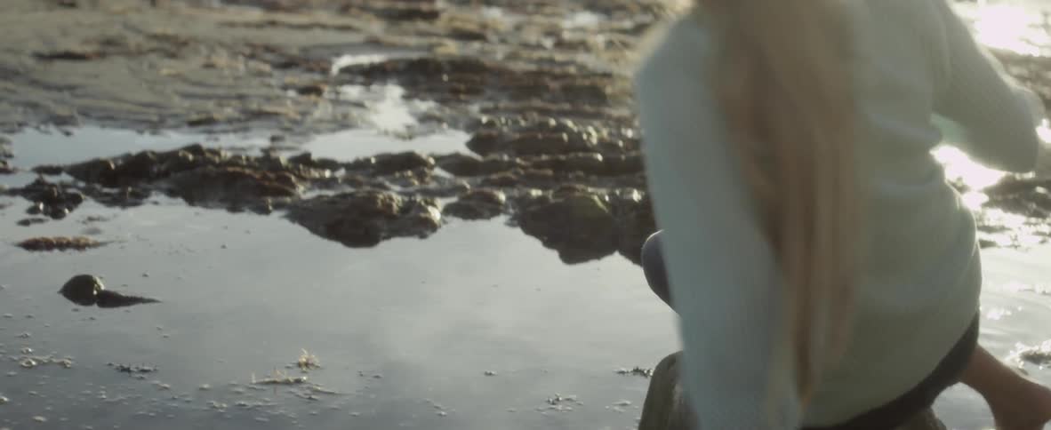 Girl is looking in a puddle then turns around