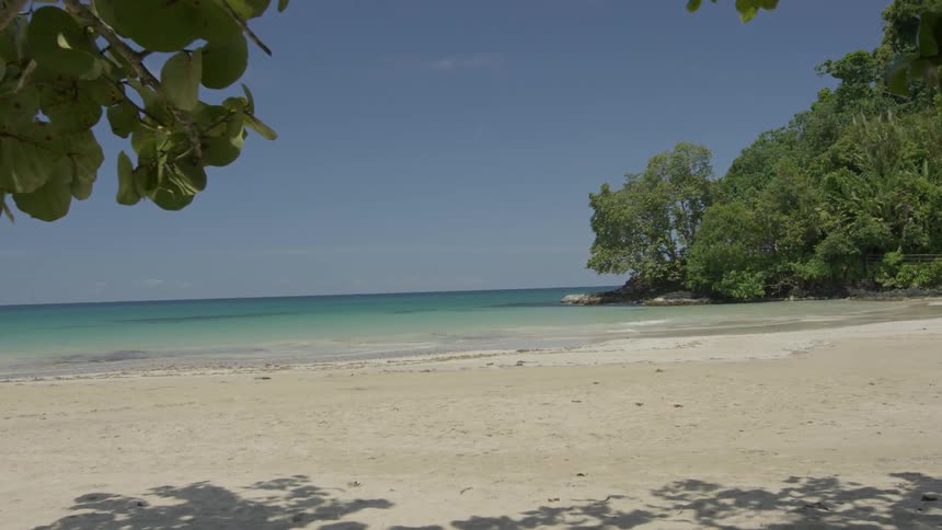 A tropical beach with clear water and calm waves