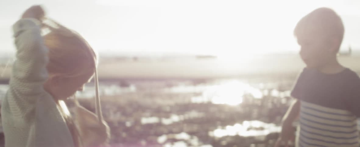 A girl sits near the ocean
