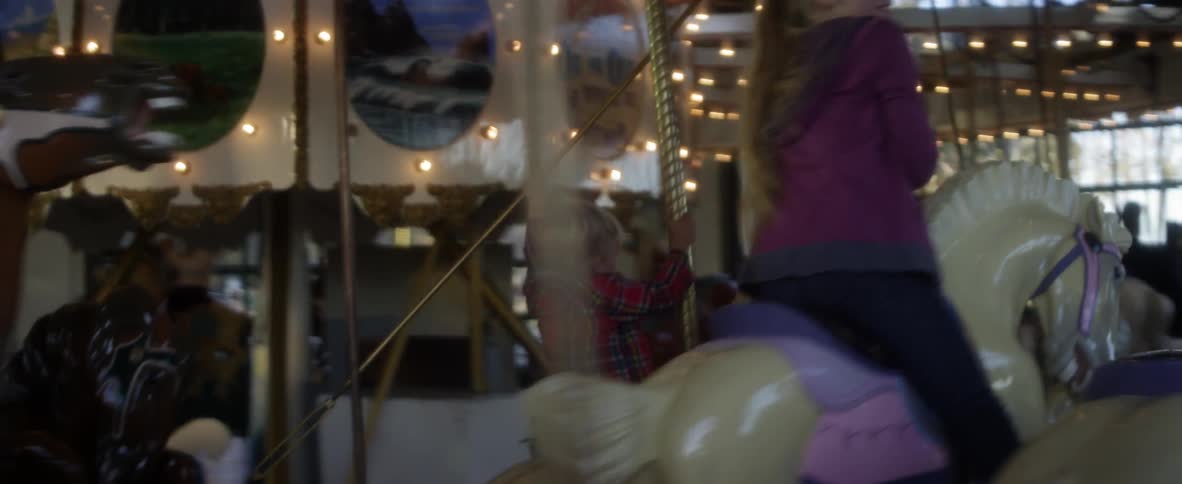 Children riding a carousel with horses